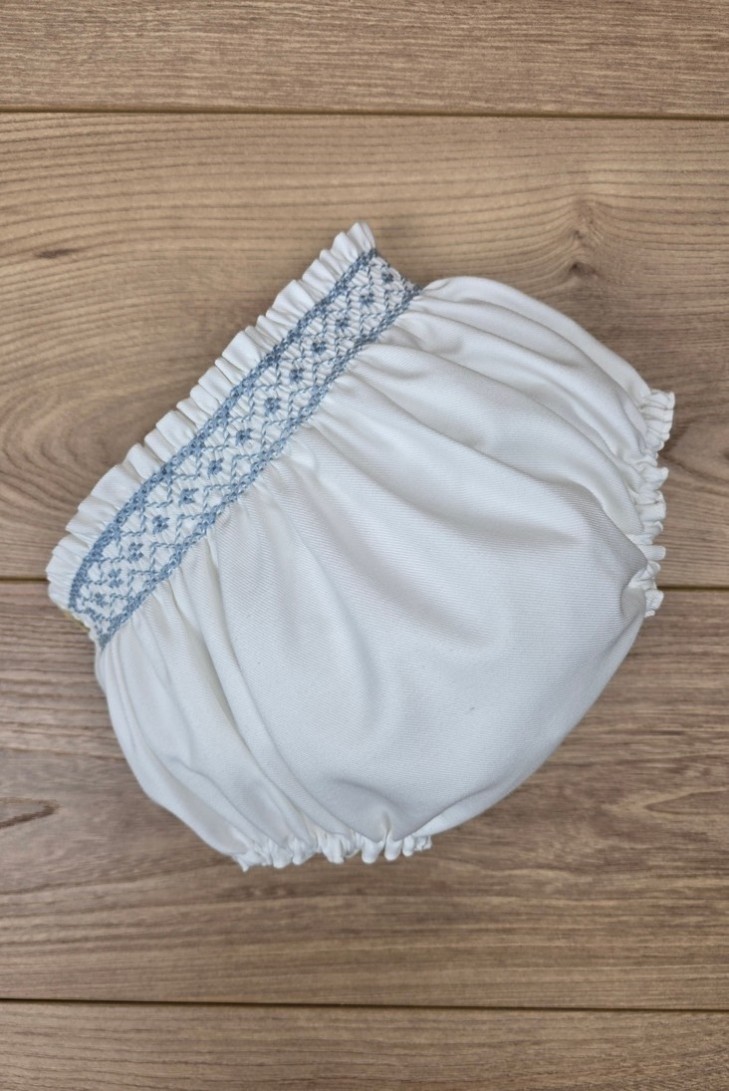 BRAGUITA VIELLA EN CRUDO BORDADA EN PUNTO SMOCK AZUL INGLÉS. ARTESANÍA CARMINA. INVIERNO 26.